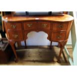 A 3' 4" 20th Century reproduction figured mahogany and cross banded kidney shaped dressing table