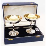 A cased pair of silver champagne coupes with parcel gilt bowls and base marks - A. E. J., Birmingham