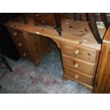 A 4' 10" late 20th Century pine knee-hole dressing table with six flanking pedestal drawers, set