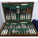 An oak canteen containing a vintage six place setting of silver plated cutlery, some with ivorine