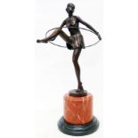 A bronzed reproduction Art Deco figure of a dancer with hoop, set on a marble socle