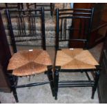 A pair of 19th Century ebonised framed Sussex style chairs with woven sea grass seat panels and