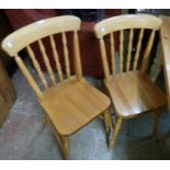 A pair of modern blonde wood Windsor style kitchen chairs with solid sectional seats, set on ring