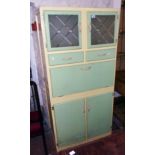 A 34" mid 20th Century painted mixed wood kitchen cabinet in powder green and cream finish, two
