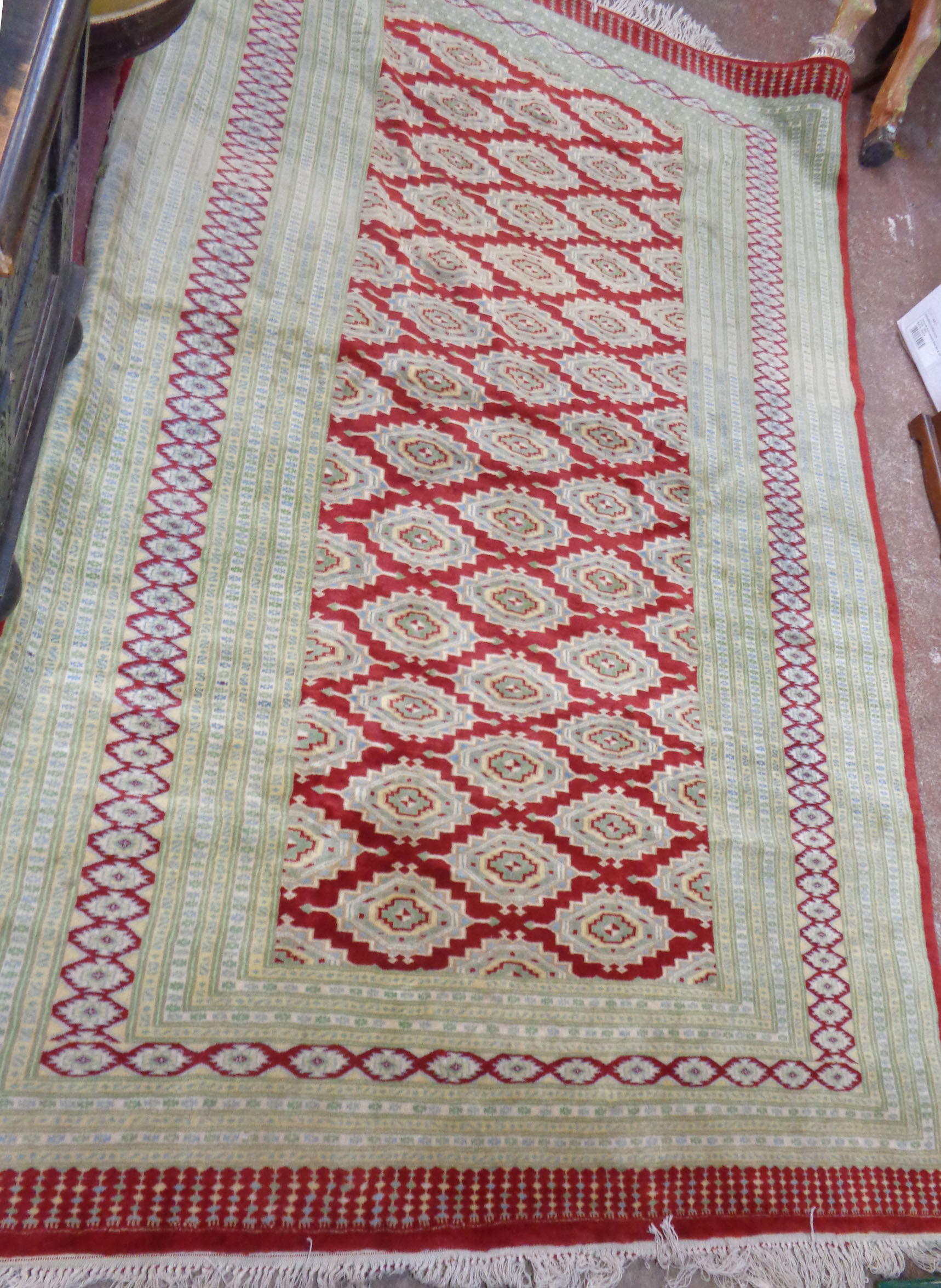 A large vintage Princess Bokhara fringe end wool rug with repeat medallion main within multi borders