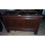 A 26 1/2" 20th Century stained oak storage box in the form of a three panel coffer, set on moulded