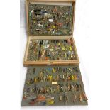A wooden case containing a collection of assorted salmon and trout fishing flies