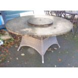 A circular garden table with composite top and plastic wicker base - diameter 4' 11"
