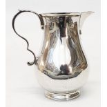 A Scottish silver baluster shaped cream jug with cast scroll handle by Wilson & Sharp - Edinburgh