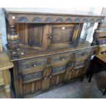 A 5' 2" 20th Century stained and carved oak court cupboard in the antique style with linen-fold