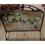 An Art Nouveau style brass and mirrored fire screen with painted floral decoration