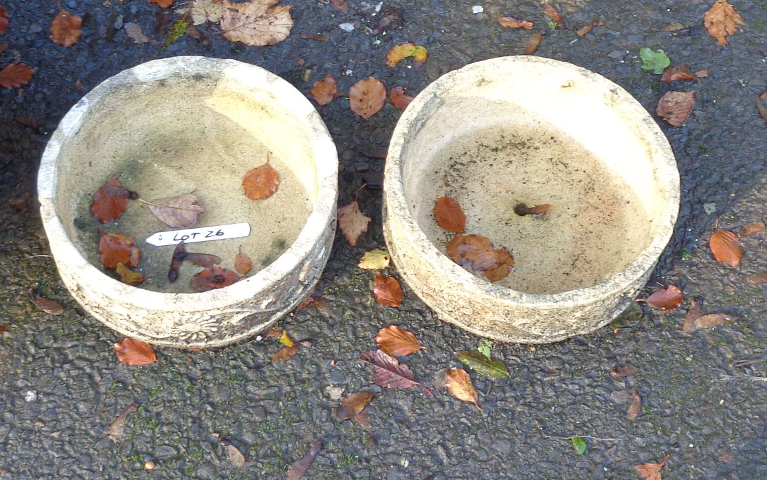 A pair of small concrete garden planters