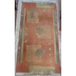 A modern rug with leaf and geometric design, green on red - 26" X 4' 4" (66cm X 132cm)