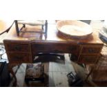 A 3' 8" reproduction figured walnut veneered and cross banded knee-hole dressing table in the