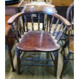 An early 20th Century stained mixed wood smoker's bow elbow chair with moulded solid seat, set on