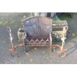 A cast iron fireplace with hunting whip, fox mask and horseshoe pattern andirons, ornate basket