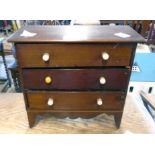 A 9" three drawer jewellery chest in the form of a Georgian chest of drawers, set on raised
