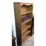 A 30" modern stained pine five shelf open bookcase, set on turned bun feet
