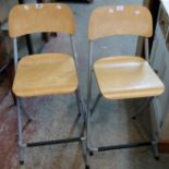 A pair of Ikea grey painted metal framed folding bar stools with laminated wood back and seat
