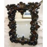 A 19th Century ornate heavily carved and pierced mahogany framed oblong wall mirror with acanthus