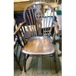 An antique wheel back elbow chair with solid elm moulded seat, set on turned supports - old repair