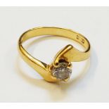 A hall marked 18ct. gold diamond solitaire cross-over ring