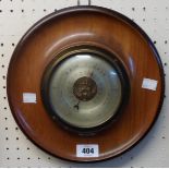 A retro moulded polished wood cased circular wall barometer with visible aneroid works to dial