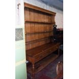 A 6' 8" 19th Century waxed pine two part dresser with moulded cornice and shaped sides to the