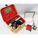 A vintage vanity case containing a quantity of costume jewellery, wristwatches and other items