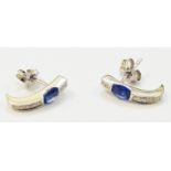 A pair of hallmarked 750 white gold curved ear-rings, each set with a cornflower blue sapphire and