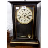 An early 20th Century ebonised and parcel gilt cased mantel clock with visible pendulum and American