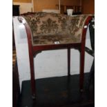 An early 20th Century stained mahogany framed scroll arm dressing chair with repeat pattern tapestry