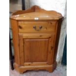 A 26 1/2" modern polished pine corner cabinet with low moulded gallery, drawer and panelled door