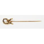 An antique yellow metal mourning stick pin with braided hair knot pattern terminal
