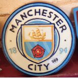 A reproduction painted cast iron Manchester City football sign