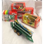 Four boxed Britains farm machines comprising Round Baler 9532, Hay Baler 9556, 4-wheeled Trailer