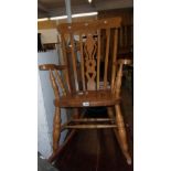 A 20th Century stained wood high lath back rocking chair with solid sectional seat, set on turned