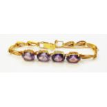 A marked 14k yellow metal fancy-link bracelet, set with four large alexandrite oval stones