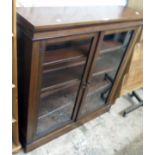 A 3' 5" Edwardian stained walnut book cabinet with adjustable shelves enclosed by a pair of glazed