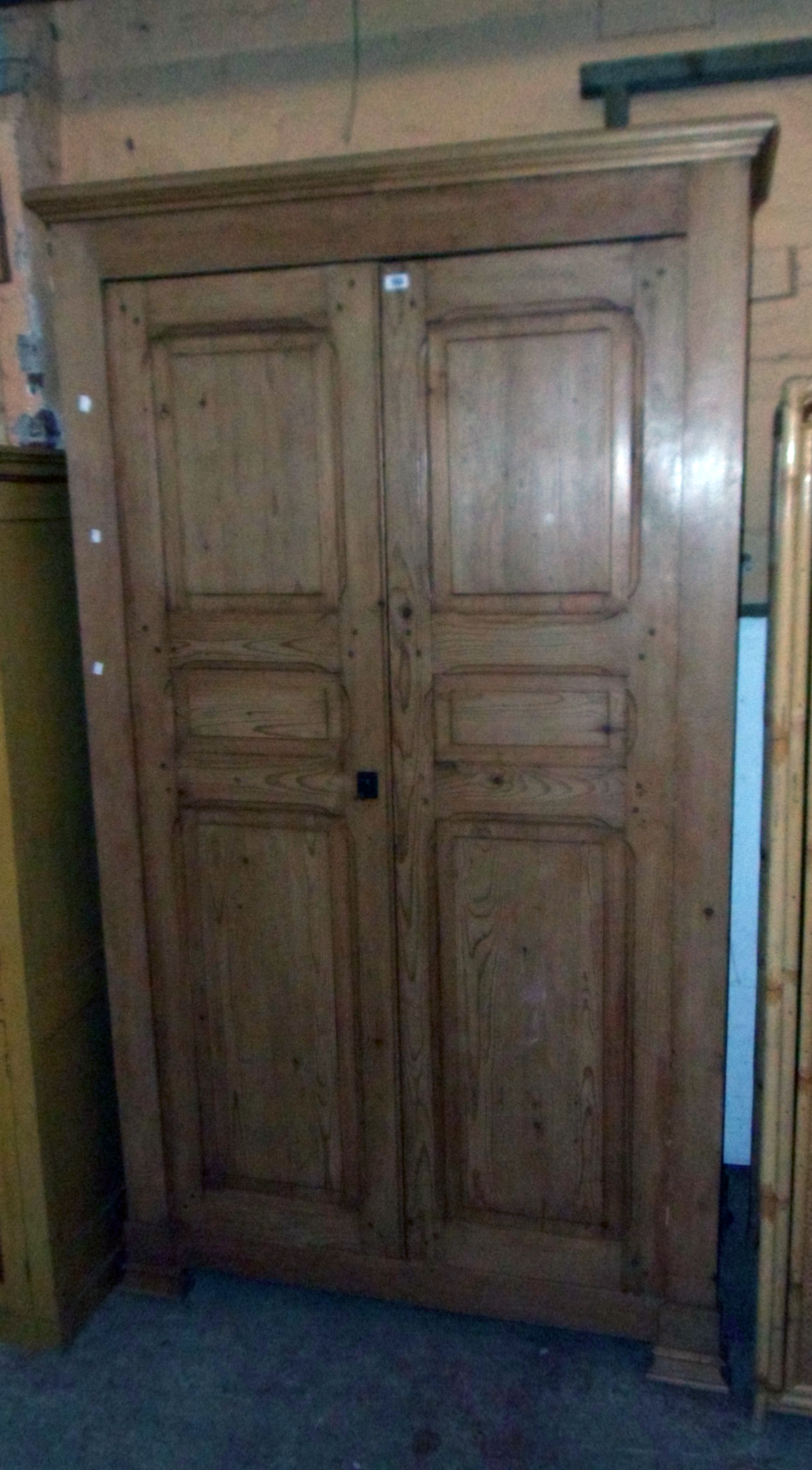 A 4' 2" waxed pine double wardrobe with moulded cornice and hanging space enclosed by a pair of