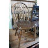 A set of four stained mixed wood wheel back kitchen chairs with thick laminated wood seat panels,