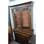 A 3' 4 1/2" early 20th Century polished oak two part book cabinet with three adjustable shelves