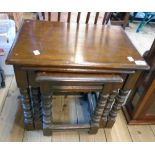 A nest of three polished oak tea tables, set on fancy turned supports and moulded stretchers