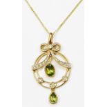 A hallmarked 375 gold Edwardian style open circular pendant, set with two pendant peridot drops