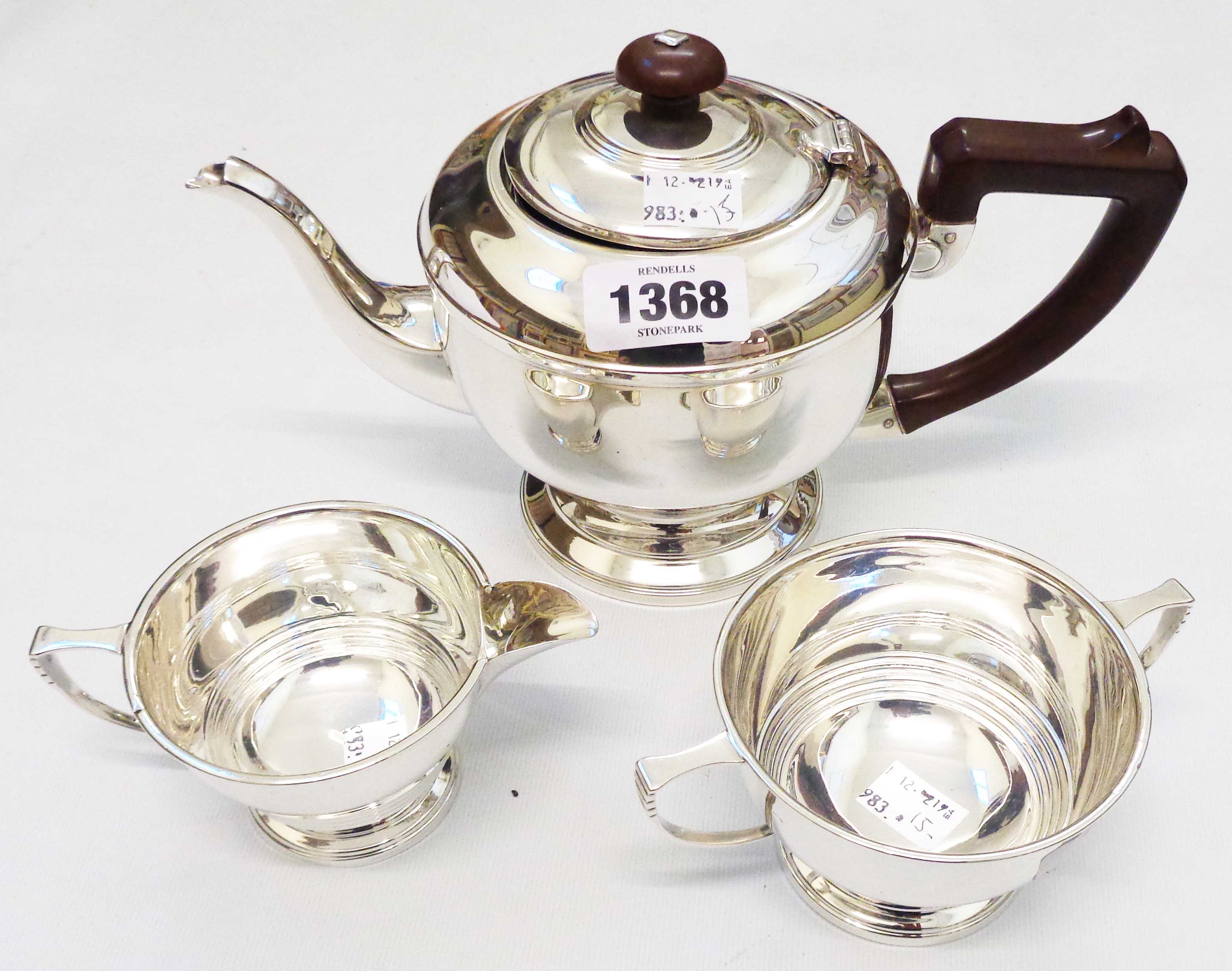 An Art Deco silver three piece tea set with banded decoration, composite knop and handle to teapot -