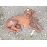 A model cast iron reclining dog in rusted finish