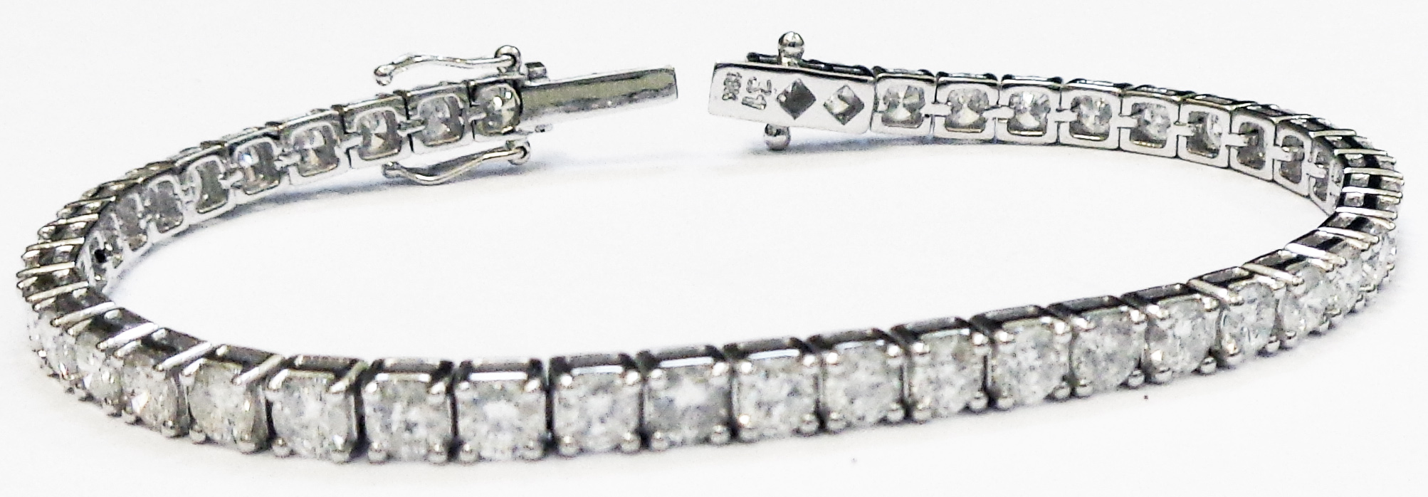 A marked 18k white metal bracelet, each of the links set with an individual brilliant cut