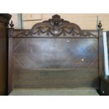 An old French walnut double bedstead with stylised shield, swag, finial and fluted decoration, the