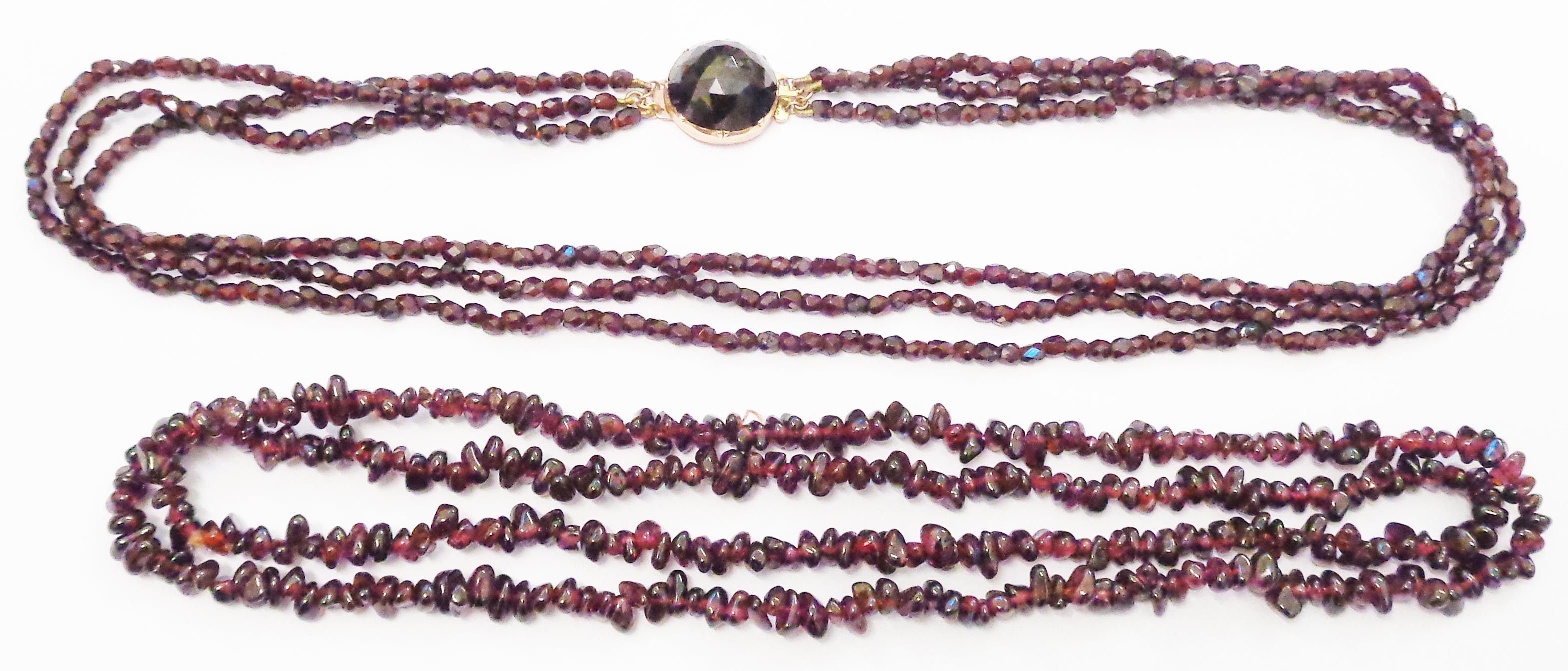 A rose metal three strand garnet bead necklace with dark faceted stone to clasp - sold with a string