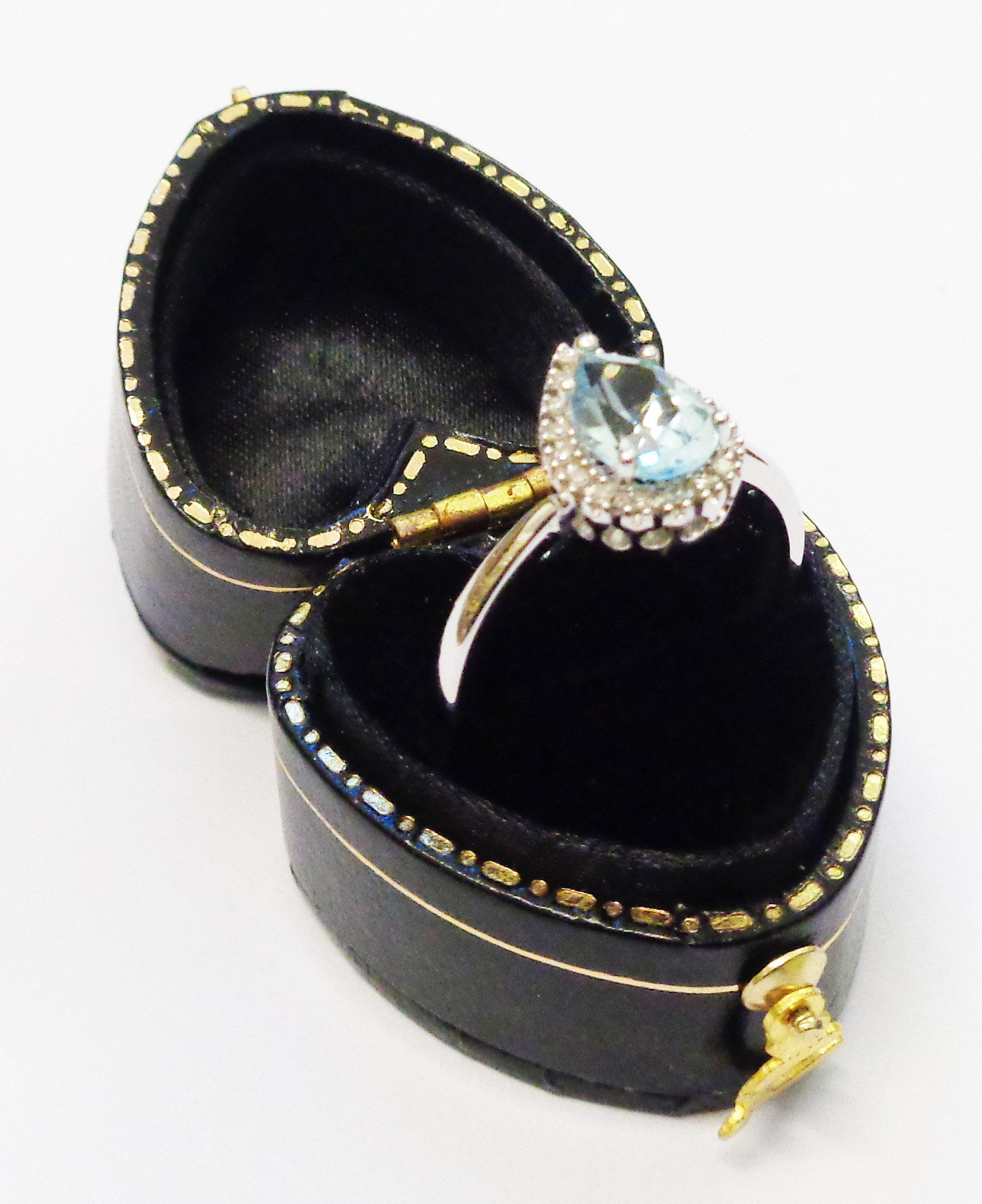 A white metal ring, set with central drop cut aquamarine within a diamond encrusted border